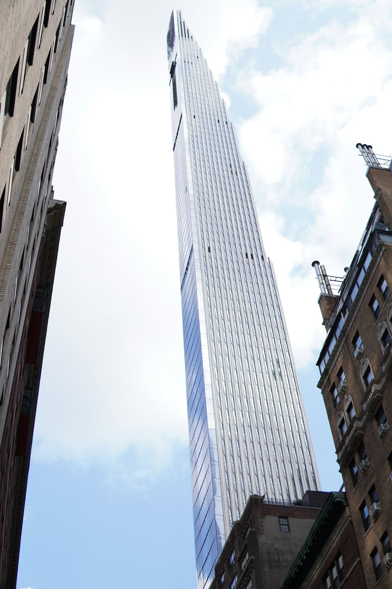 Steinway Tower at 111 West 57th Street seen from the street below, rising slender between older Manhattan buildings