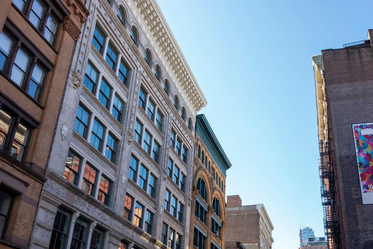 Cast-iron building facades in SoHo, New York, under a clear sky